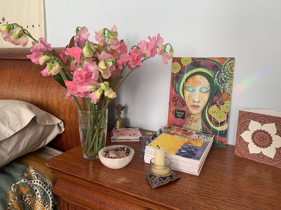 Bedside altar with flowers, crystals, art